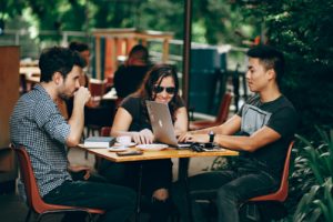 photo of three person sitting and talking